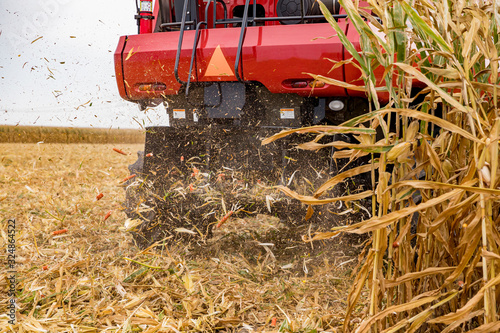 Foto Closeup of chaff spreader on combine harvester harvesting cornfield