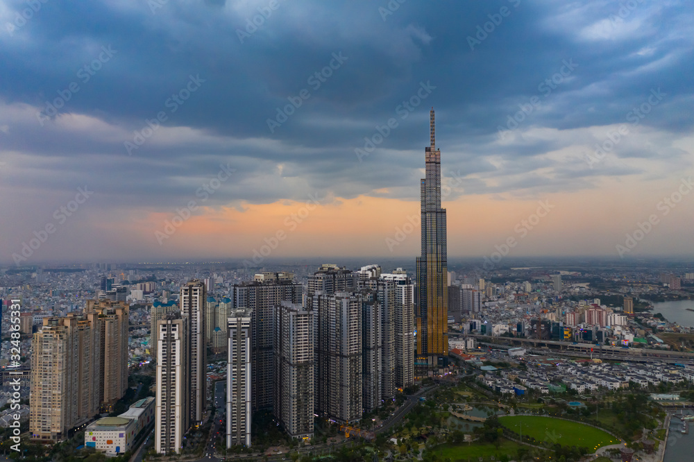 Obraz premium Dramatic aerial view of Landmark Building and Ho Chi Minh City skyline at sunset with beautiful stormy and dark clouds in the sky