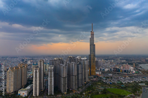 Dramatic aerial view of Landmark Building and Ho Chi Minh City skyline at sunset with beautiful stormy and dark clouds in the sky
