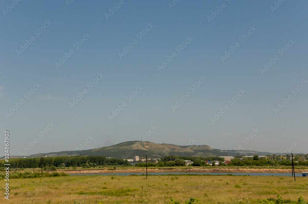 Light white clouds in the warm summer sky over village with small houses far away in the fields. Travelling. People living Light white clouds in the warm summer sky over village with small houses far away in the fields. Travelling. People living