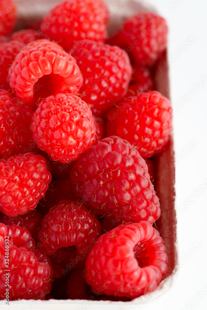 Freshly picked organic raspberries in recycled paper cup. High resolution, white background Freshly picked organic raspberries in recycled paper cup. High resolution, white background