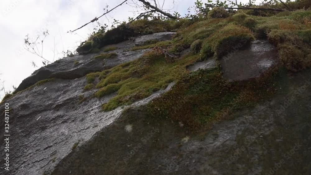 Water drops fall and break on rocks and moss, melting snow in the mountains at spring season, slow motion shot from below slightly movement like dolly effect Water drops fall and break on rocks and moss, melting snow in the mountains at spring season, slow motion shot from below slightly movement like dolly effect