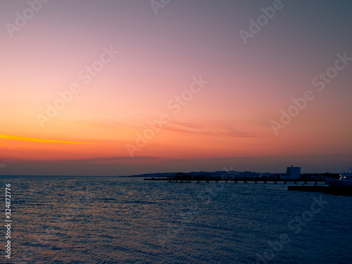 Beautiful dramatic sunset over the ocean. Sunrise on sea skyline. Waves over beach coast for wallpaper © Vladyslav