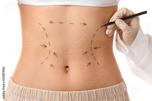 Plastic surgeon applying ma...