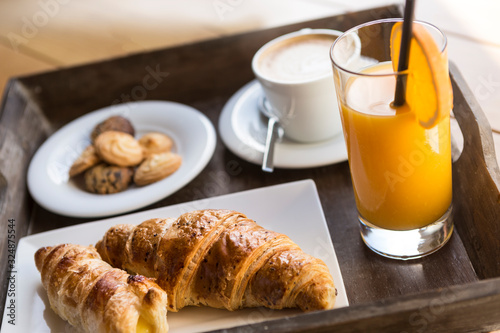 Colazione all'Italiana con cappuccino cornetto succo d'arancia e biscottini