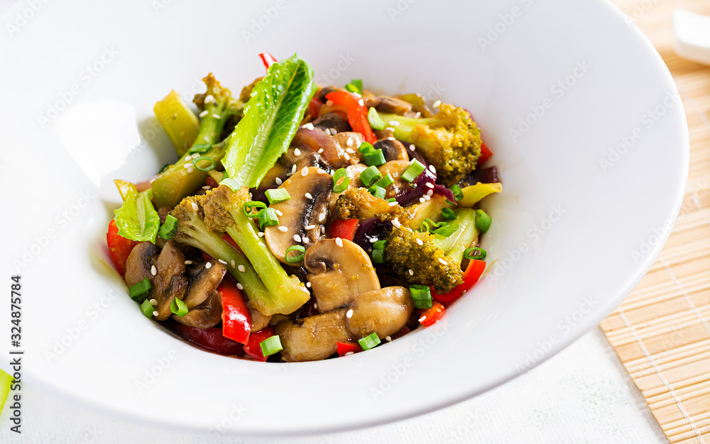 Stir fry vegetables with mushrooms, paprika, red onions and broccoli. Healthy food. Asian cuisine.