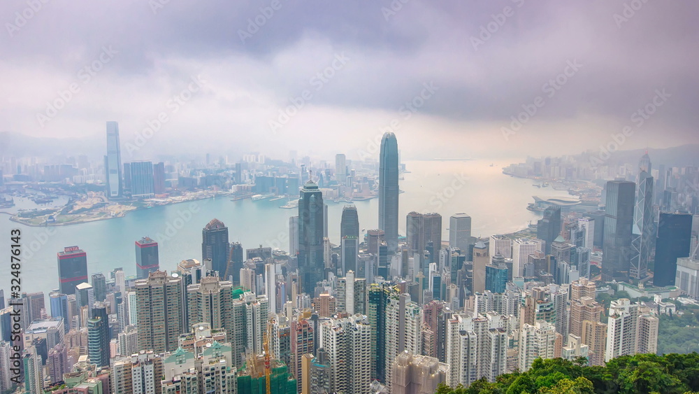 The famous view of Hong Kong from Victoria Peak night to day timelapse. Taken before sunrise with colorful clouds over Kowloon Bay.