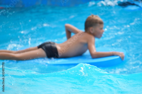 Baby boy on a water Board. Stay in the water Park in the summer.
