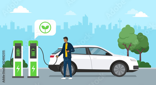 Man charging his electric car at the charging station photo