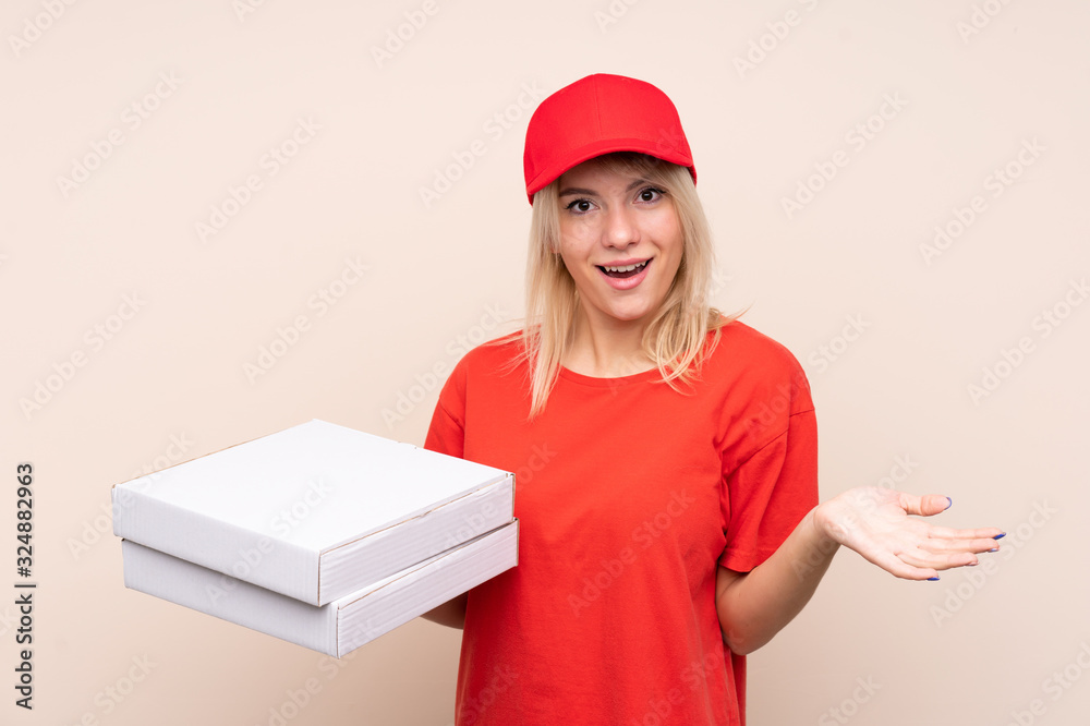 Pizza delivery Russian woman holding a pizza over isolated wall with shocked facial expression Pizza delivery Russian woman holding a pizza over isolated wall with shocked facial expression