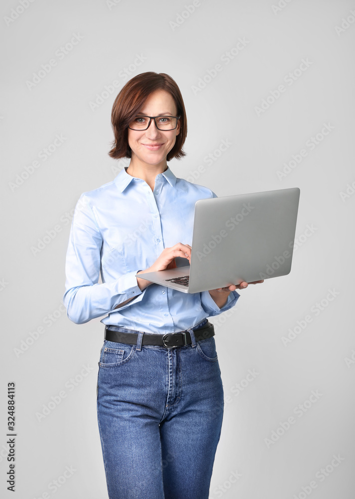 Beautiful woman with laptop in hand on gray background Beautiful woman with laptop in hand on gray background