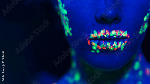Close-up view of women's lips and fluorescent make-up