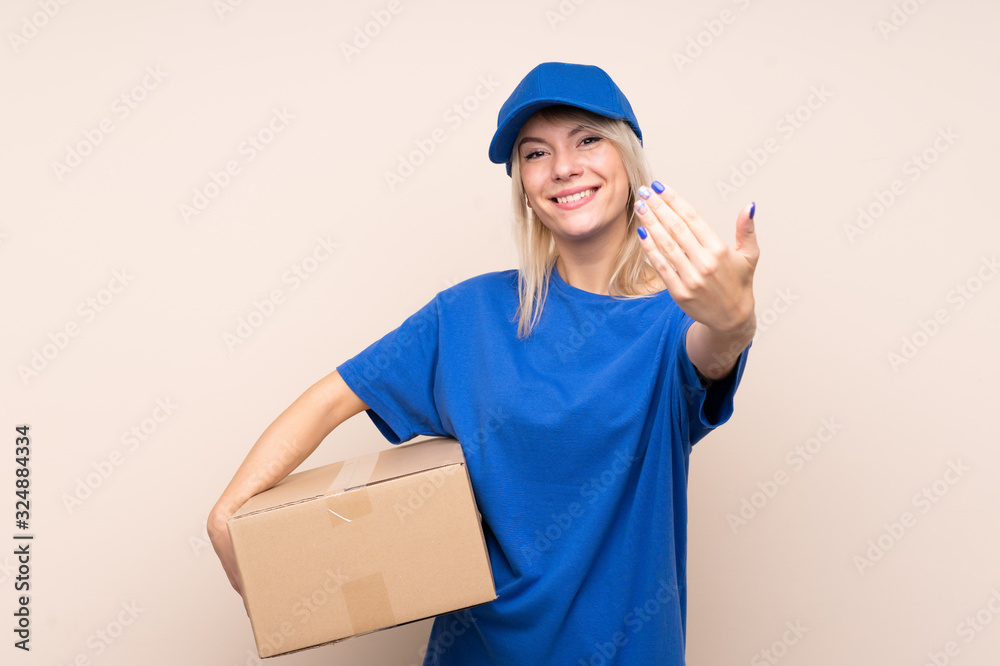 Young delivery woman over isolated background inviting to come Young delivery woman over isolated background inviting to come