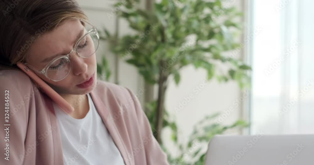 Businesswoman analyzing documents while talking on mobile phone at office Businesswoman analyzing documents while talking on mobile phone at office