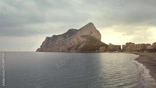 Aerial view big rock near Parque natural del Penon de Ifach in Calpe, symbol of Calpe town, 4k footage. Province of Alicante, Costa Blanca, Spain