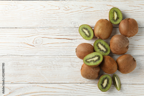 Ripe fresh kiwi on wooden background, top view and space for text