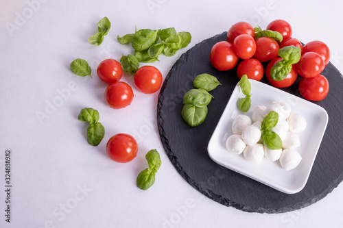 basil, mozzarella and tomatoes on a table