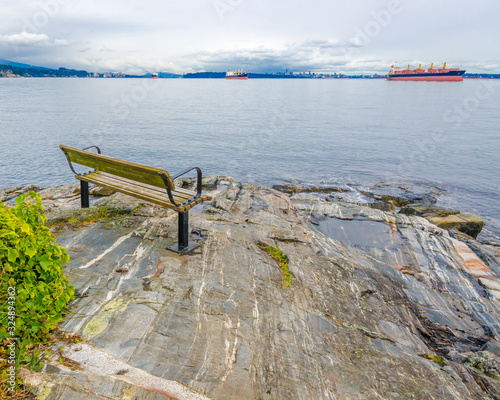 A bench on a rocky beach with gorgeous view at Ocean, British Columbia, Canada. photo