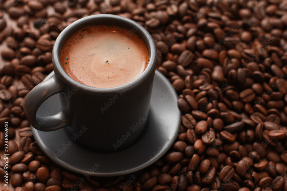 Grey cup of coffee with foam, dark roasted beans. Closeup, copy space, top view. Coffee shop, espresso, fresh roast, drink concept Grey cup of coffee with foam, dark roasted beans. Closeup, copy space, top view. Coffee shop, espresso, fresh roast, drink concept