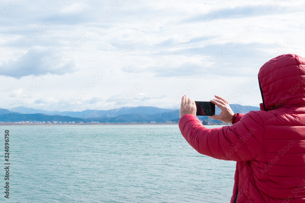 Unrecognisable man taking photos with smartphone. Admiring the nature, wanderlust