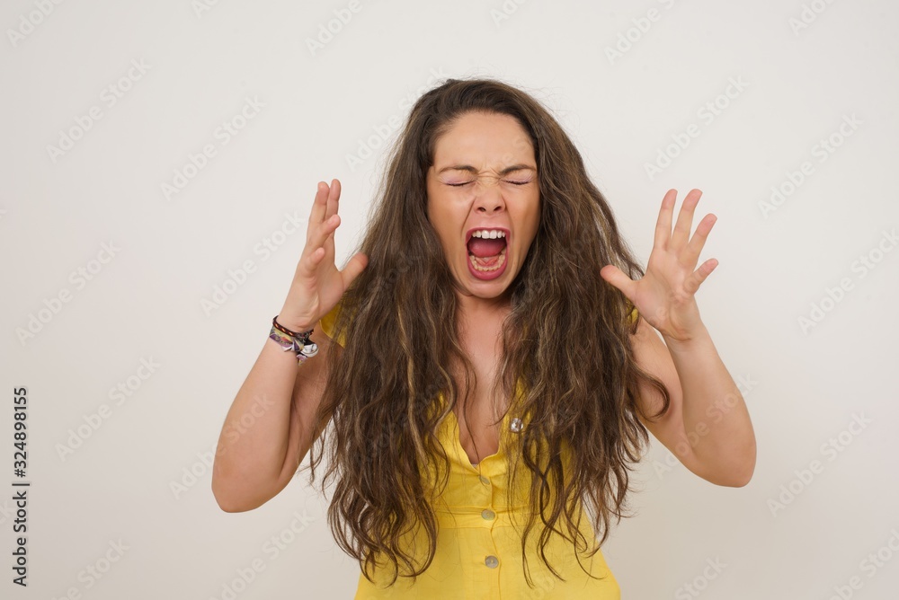 Screaming, hate, rage. Crying emotional angry woman screaming on blue studio background. Emotional, young face. Female half-length portrait. Human emotions, facial expression concept. Trendy colors Screaming, hate, rage. Crying emotional angry woman screaming on blue studio background. Emotional, young face. Female half-length portrait. Human emotions, facial expression concept. Trendy colors