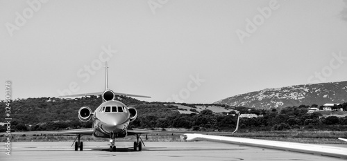 Amazing black and white shot of a beautiful private business Falcon jet on the tarmac of Figari airport. Jet set lifestyle during summertime in the south of France.