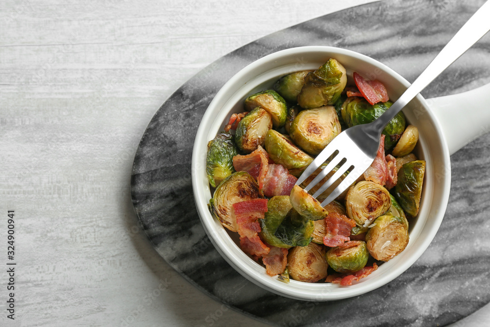 Roasted Brussels sprouts with bacon served on white wooden table, top view Roasted Brussels sprouts with bacon served on white wooden table, top view