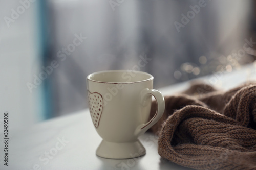 Delicious morning coffee and knitted sweater on white table indoors
