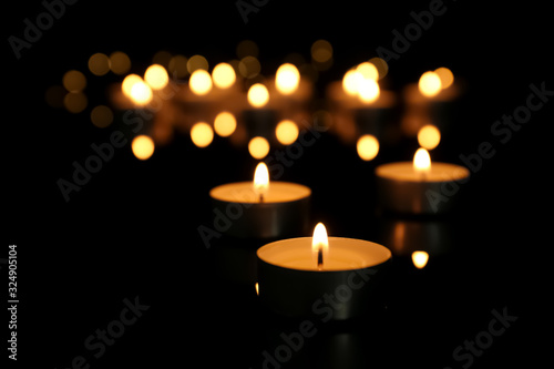 Burning candle on table against blurred background