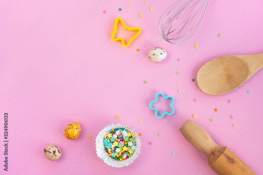 Easter baking background. Eggs, spoon, rolling pin, whisk, colorful confetti and cookie cutters on light pink table. Cooking concept and holiday. Top view, flat lay, copy space Easter baking background. Eggs, spoon, rolling pin, whisk, colorful confetti and cookie cutters on light pink table. Cooking concept and holiday. Top view, flat lay, copy space