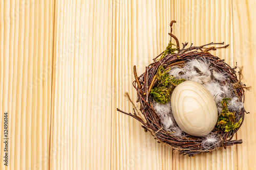 Easter bird nest. Zero waste, DIY concept. Wooden egg, feathers, moss. Boards background photo