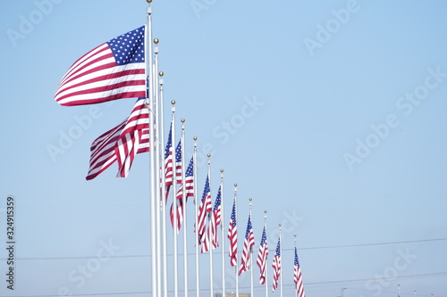 american flags in front of blue sky