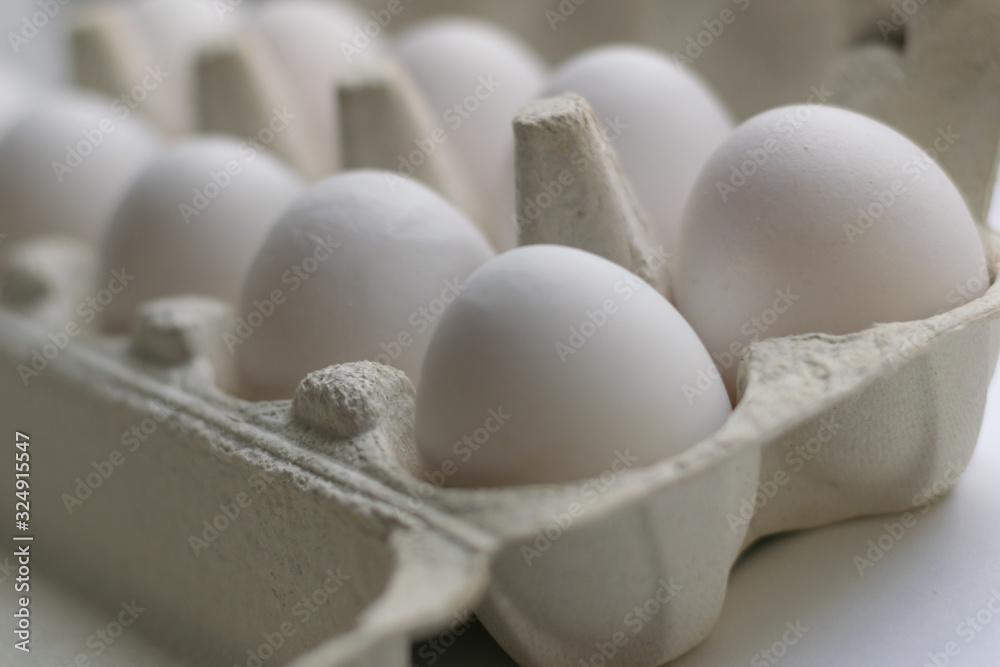 Cardboard egg box with ten eggs isolated on white. Front view. Cardboard egg box with ten eggs isolated on white. Front view.