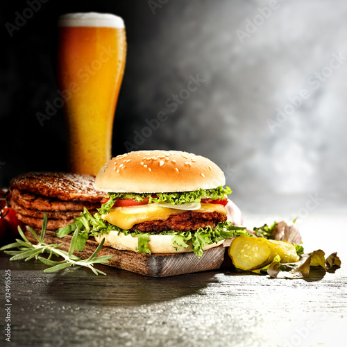 Fresh hot hamburger on dark space and cold beer 