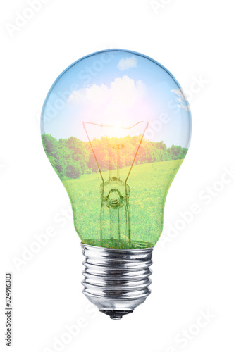 Fotografie Light bulb with grassland and blue sky inside on white background
