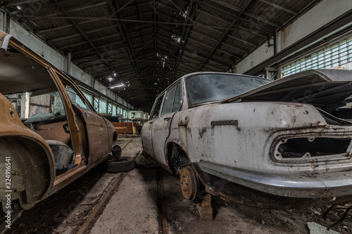 alte rostige autos in einer halle