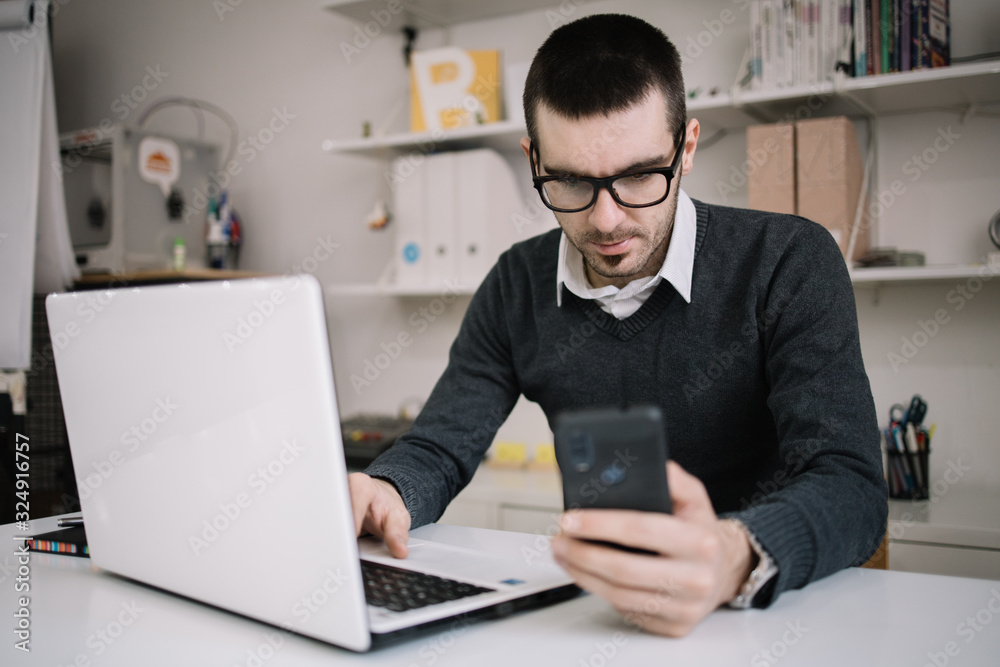 Businessman looking at his phone while working Businessman looking at his phone while working