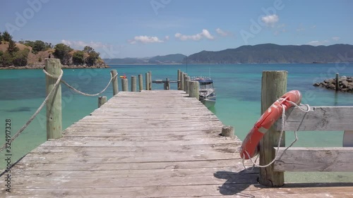 A jetty extends out into the bay on scenic Slipper Island, New Zealand photo