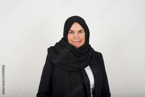 Beautiful muslim woman nervous and scared biting lips looking camera with impatient expression, pensiveï¿½