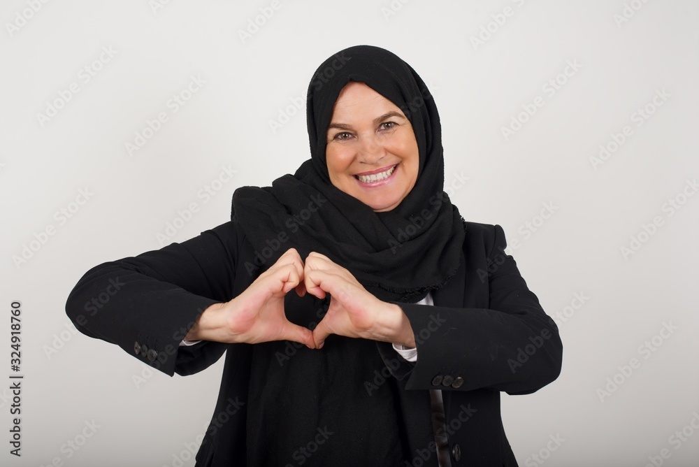 Beautiful caucasian woman over isolated background smiling in love showing heart symbol and shape with hands. Romantic concept. Beautiful caucasian woman over isolated background smiling in love showing heart symbol and shape with hands. Romantic concept.
