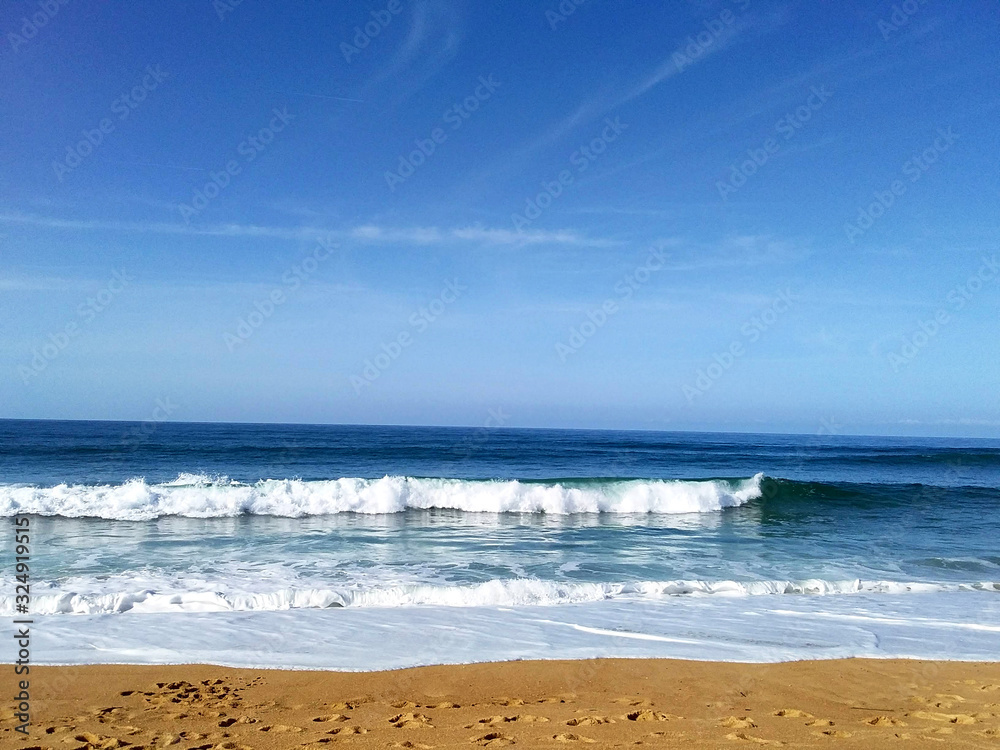 Soft wave of blue ocean on sandy beach. Background.