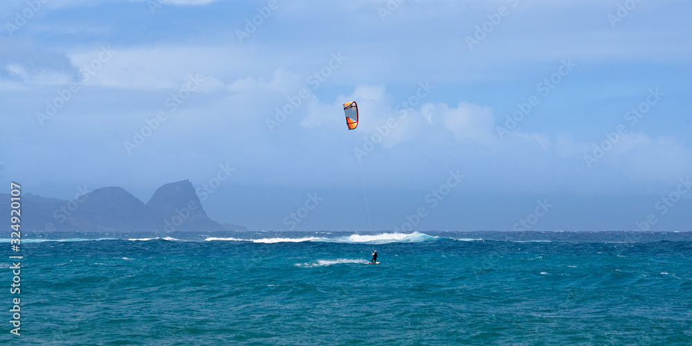 Panoramic view of the ocean with kite surfer on a windy day on Maui island in Hawaii. Panoramic view of the ocean with kite surfer on a windy day on Maui island in Hawaii.