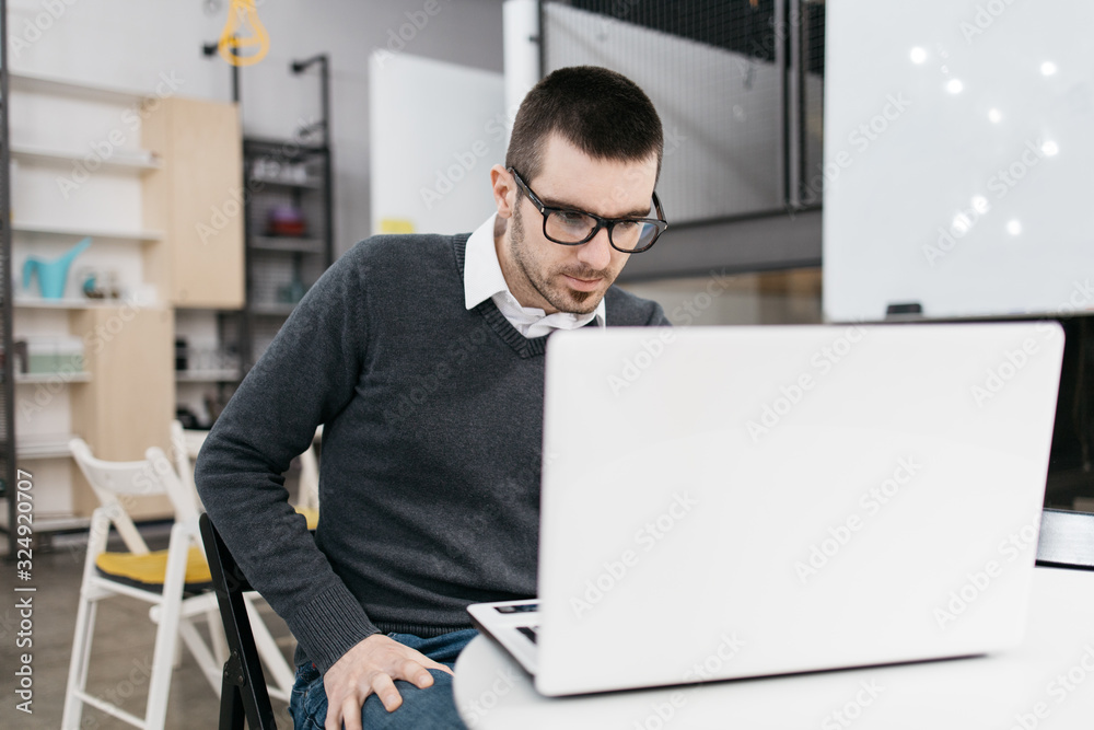 Fototapeta premium Focused man working on laptop in the office