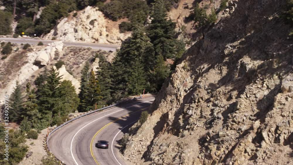 Car drives up mountain road in California, aerial Car drives up mountain road in California, aerial