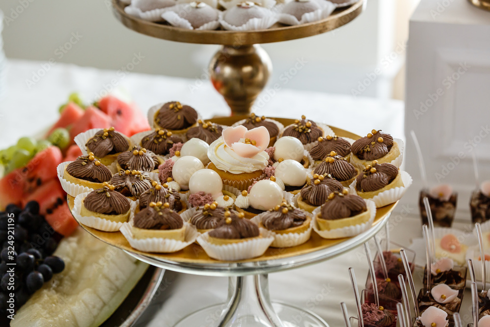 Set of delicious chocolate cupcakes and muffins with white icing. Banquet table for Mothers Day, Valentines Day