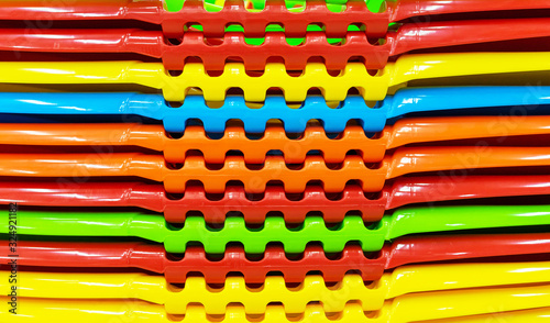 Multi-colored plastic containers stacked in a stack.