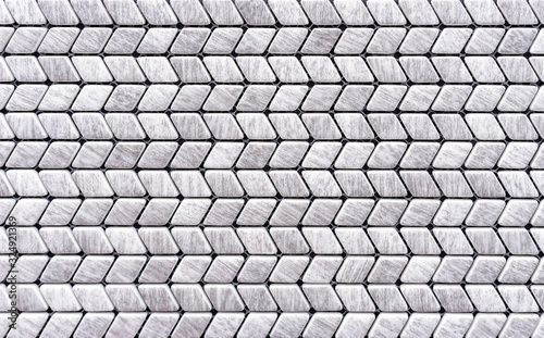Gray mosaic tiles are laid out in the shape of a herringbone.
