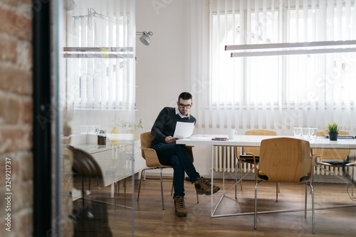 Fotografie Man sitting in office breakout area and reading