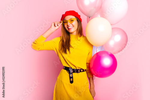 Beauty girl with colorful air balloons laughing, isolated on white background. Beautiful Happy Young woman on birthday holiday party. Joyful model having fun and celebrating with pastel color balloon