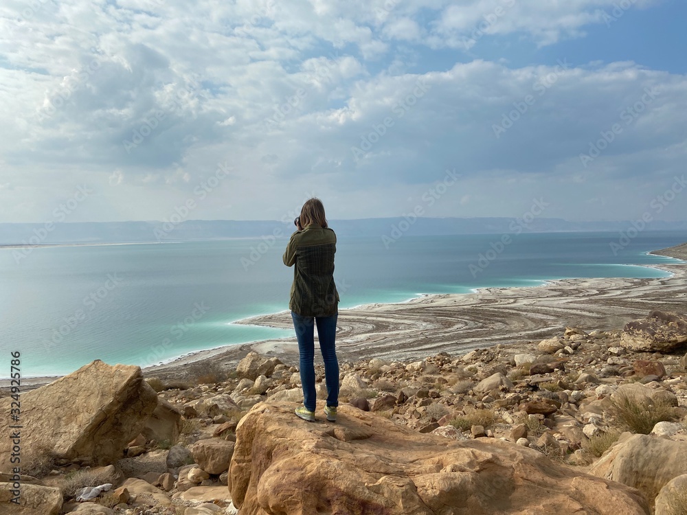 Woman photographing the Death Sea beach in Jordan landscape envi